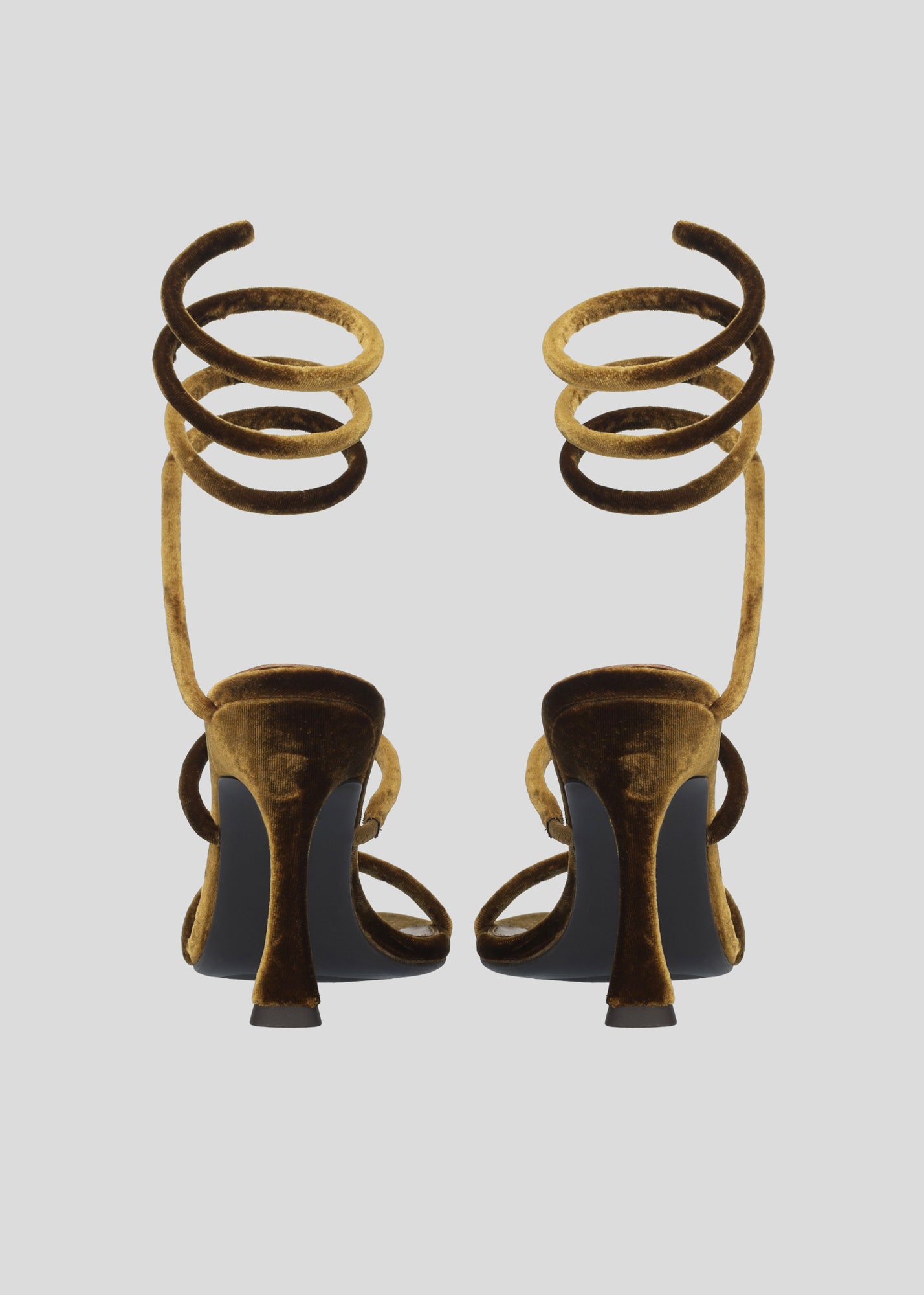Vista lateral de las sandalias de terciopelo para mujer Greta Sandal 95 en color ocre con correa tubular en espiral al tobillo y tacón tipo embudo de Lola Cruz.