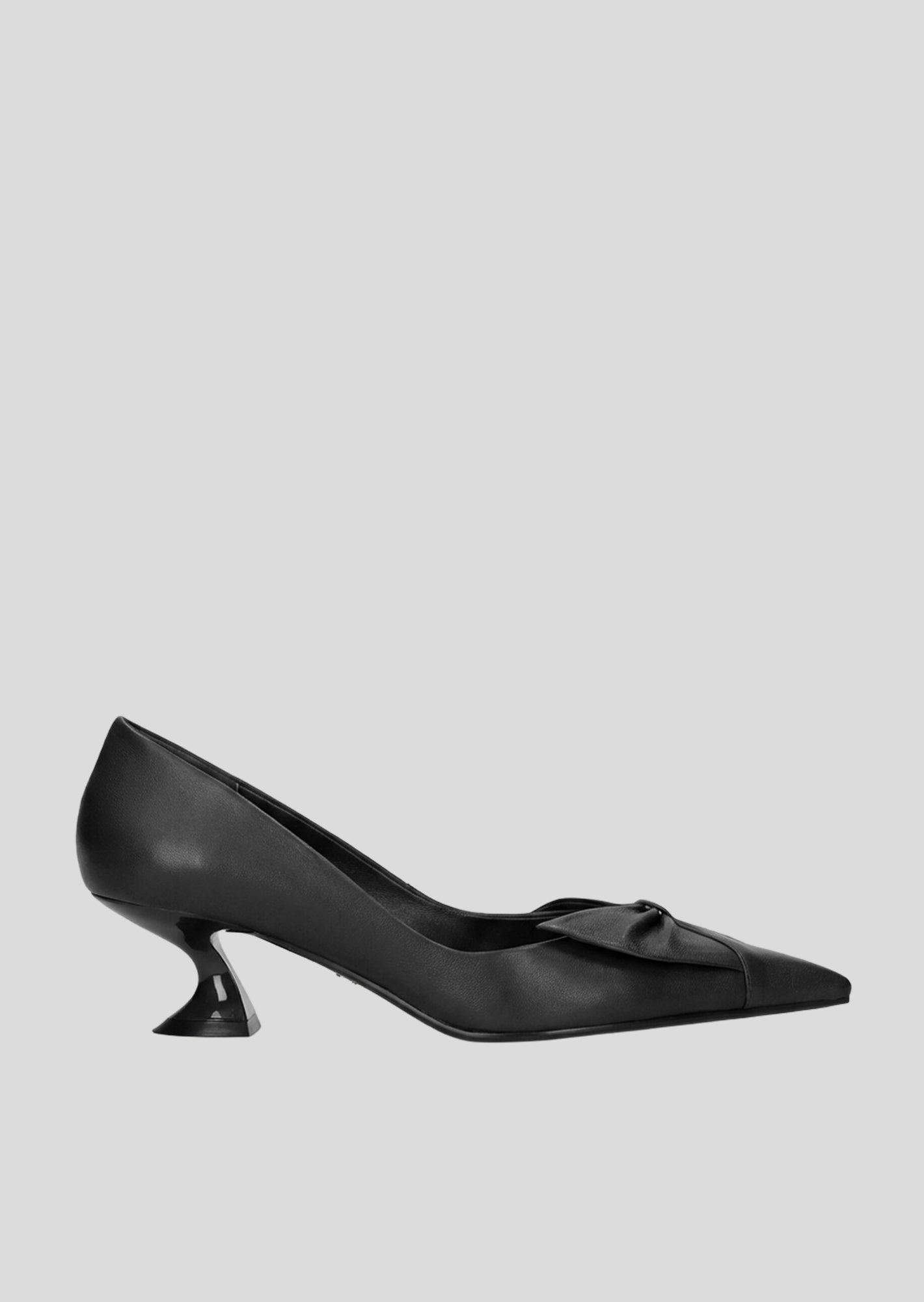 Vista lateral de los zapatos de salón de piel para mujer Manuela Pumps 50 en color negro con punta afilada, lazo de piel y tacón tipo embudo de Lola Cruz.