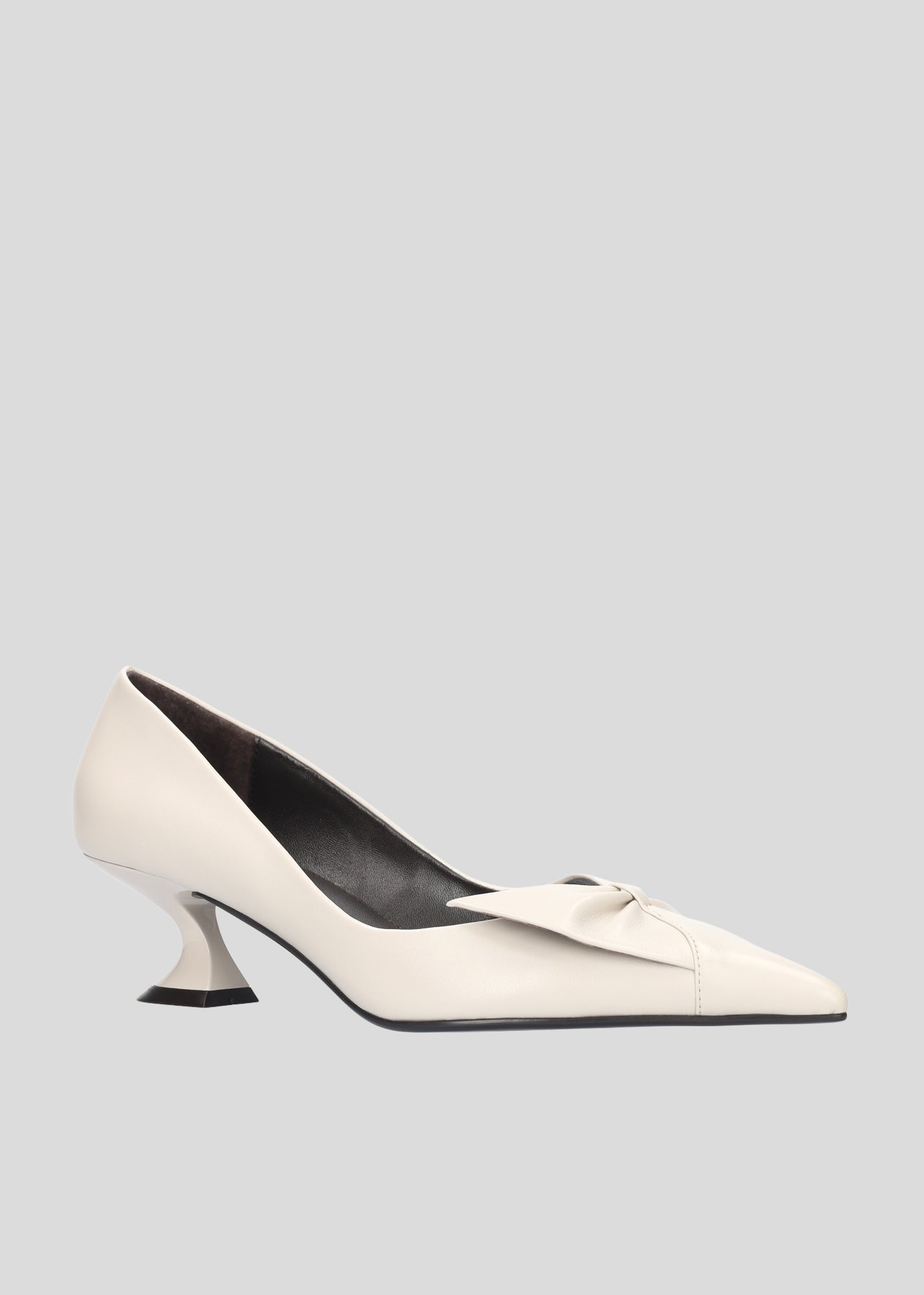 Vista lateral de los zapatos de salón de piel para mujer Manuela Pumps 50 en color Ecru con punta afilada, lazo de piel y tacón tipo embudo de Lola Cruz.